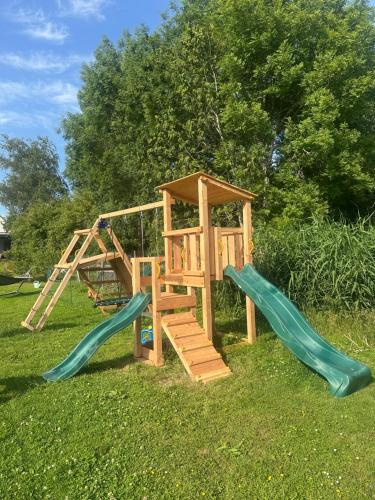 a wooden playground with two slides and a ladder at Het Spoel in Kuilenburg