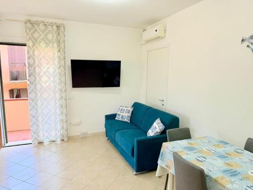 a living room with a blue couch and a table at Isabel Apartment in Porto Azzurro