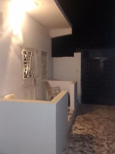 a white room with a table and a chair at LMD Apartments in Kololi