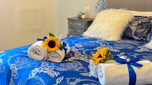 a blue and white bed with towels and sunflowers on it at B&B Antenna 2 by Ca-Sa Check in Chioggia