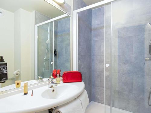 y baño con lavabo y ducha acristalada. en ibis budget Cavaillon, en Cavaillon