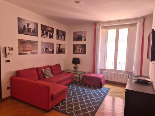 a living room with a red couch and a table at Phi Hotel Bologna in Bologna