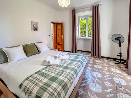 a bedroom with a large bed with towels on it at Garden Paradise - Free Parking - Terminal 4min in Savona