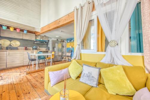 un salon avec un canapé jaune et une cuisine dans l'établissement Dari, à Bordeaux
