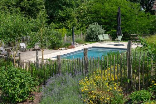 a swimming pool in a garden with a fence at Maison Le Garochet in Digoin