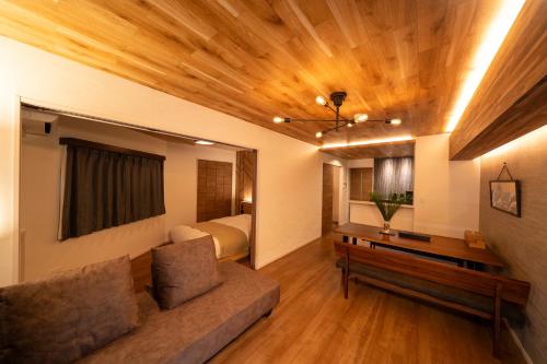 a living room with a couch and a bed at ザ サウンドクレスト五条駅前 in Dazaifu