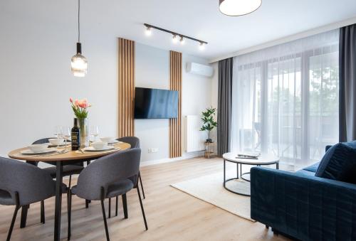 a living room with a table and chairs and a couch at Mielno Residence in Mielno