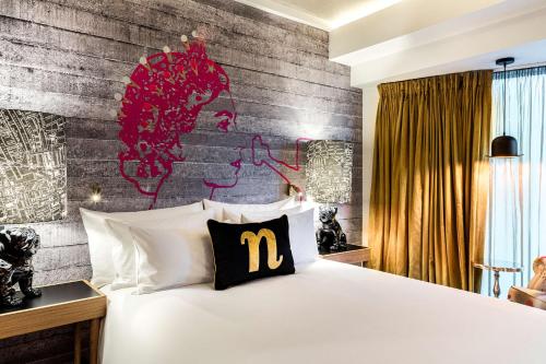 a bedroom with a bed with a m pillow on it at nhow London in London