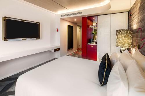 a bedroom with a bed and a tv on a wall at nhow London in London