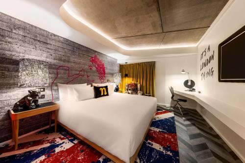 a bedroom with a large white bed and a brick wall at nhow London in London