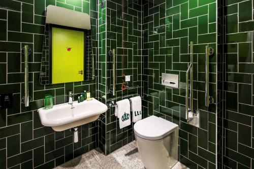 a bathroom with a sink and a toilet and a mirror at nhow London in London