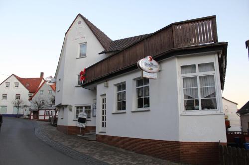 a white building on the side of a street at Hotel- Restaurant Zum Kleinen König in Bad Zwesten