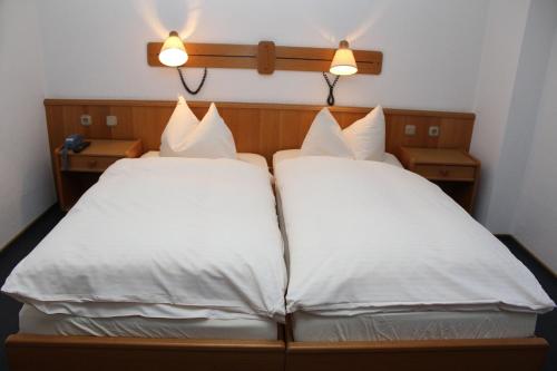 Hotel- Restaurant Zum Kleinen König في باد سفيستِن: سريرين في غرفة الفندق مع وسائد بيضاء