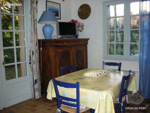 une salle à manger avec une table avec des chaises et une télévision dans l'établissement le pigeonnier, à La Celle-sous-Gouzon
