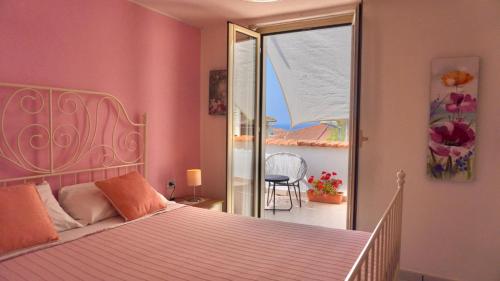 a bedroom with a bed and a view of a balcony at Caramico Room in Castellabate