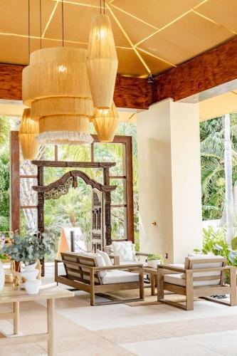 a living room with benches and a chandelier at Soul Spring Sanctuary Cuernavaca in Xochitepec