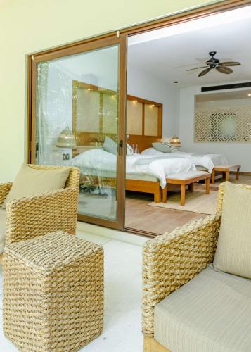 a bedroom with a bed and a couch and chairs at Soul Spring Sanctuary Cuernavaca in Xochitepec