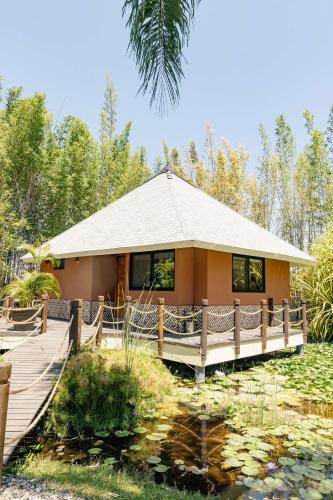 a small house with a bridge over a pond at Soul Spring Sanctuary Cuernavaca in Xochitepec