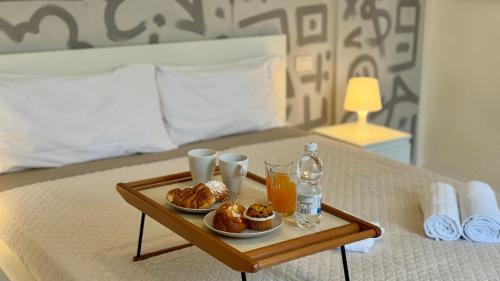 a tray of food on a bed with drinks and pastries at AxelParkComo in Como