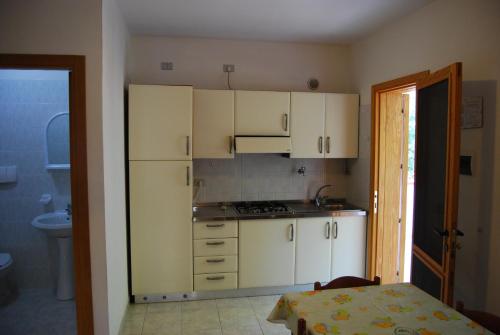 a small kitchen with white cabinets and a sink at Villaggio Mascia in Vieste