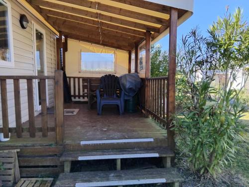 une terrasse couverte d'une maison avec une table et des chaises dans l'établissement Camping la côte Vendeenn, à Talmont-Saint-Hilaire