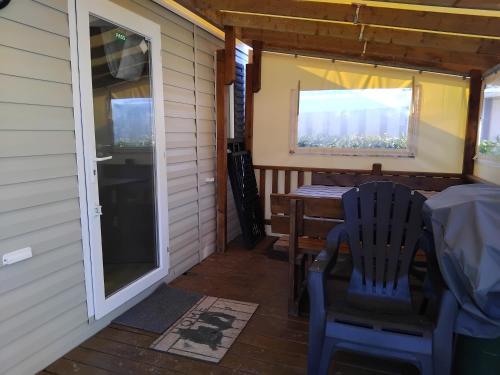 une véranda avec une table, des chaises et une fenêtre dans l'établissement Camping la côte Vendeenn, à Talmont-Saint-Hilaire