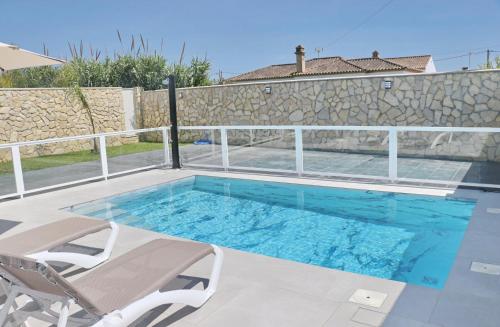 a swimming pool with two lounge chairs and a swimming pool at El Rincon de Samuel in Conil de la Frontera