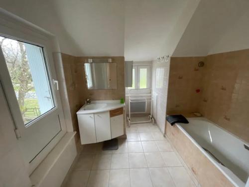 une salle de bain avec une baignoire et un lavabo et une baignoire dans l'établissement Maison 4 à 6 personnes à Sables d'Or les Pins près de la plage et du golf, à Fréhel