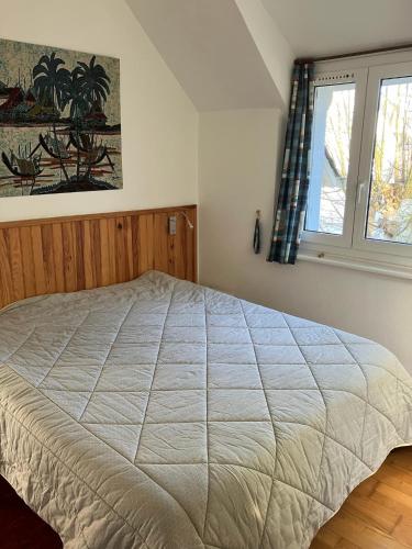 une chambre avec un grand lit avec une fenêtre dans l'établissement Maison 4 à 6 personnes à Sables d'Or les Pins près de la plage et du golf, à Fréhel