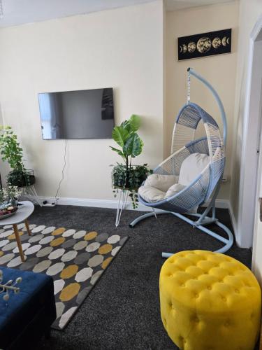 a living room with a chair and a swing at Glamorous and stylish in Wolverhampton