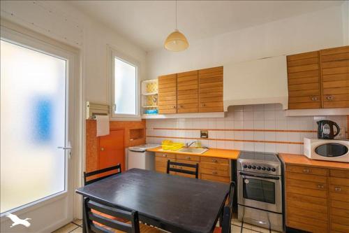 une cuisine avec une table et une cuisinière four supérieur dans l'établissement Villa chanterelle, à Meschers-sur-Gironde