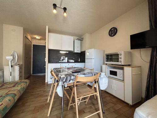 une cuisine avec une table et des chaises dans une pièce dans l'établissement Studio Cabine - CAP AGDE CT045-077, au Cap d'Agde