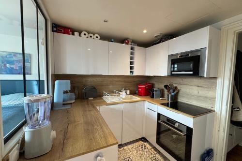 une cuisine avec des armoires blanches et un comptoir dans l'établissement Spacious apartment close to the beach, à Trouville-sur-Mer