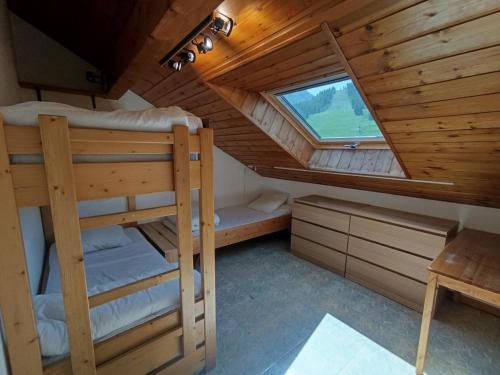 une chambre avec deux lits superposés et une fenêtre dans l'établissement Duplex 6 pers, 2*, skis aux pieds, animaux admis, ascenseur - FR-1-445-50, à Montgenèvre