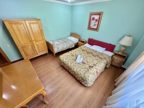 a small bedroom with a bed and a dresser at Hotel Lileo in Mestia