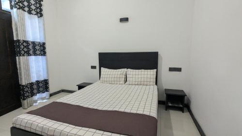 a bedroom with a large bed with two tables at The Village - Ella in Bandarawela