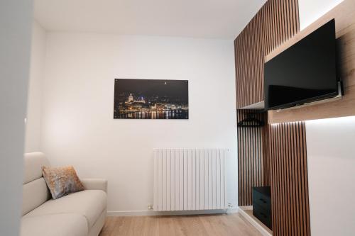 a living room with a couch and a flat screen tv at Como Charm Living Apartment Duomo in Como