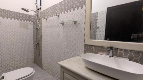 a bathroom with a sink and a toilet and a mirror at The Village - Ella in Bandarawela