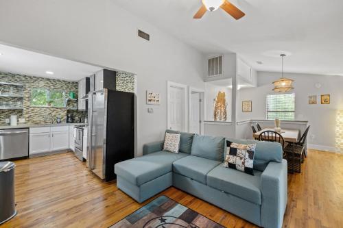 a living room with a blue couch and a kitchen at 4BR house in trendy East Austin in Austin