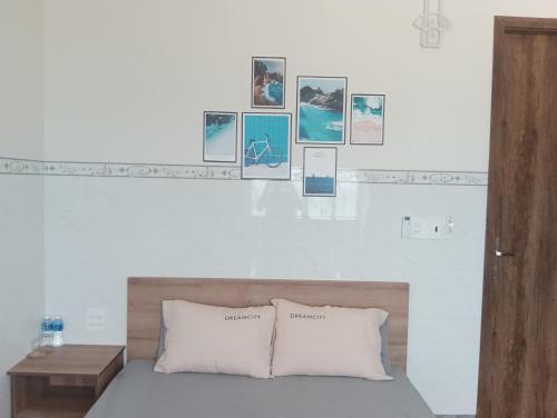 a bedroom with a bed with pictures on the wall at Homestay Dâu in Îlot du Sud