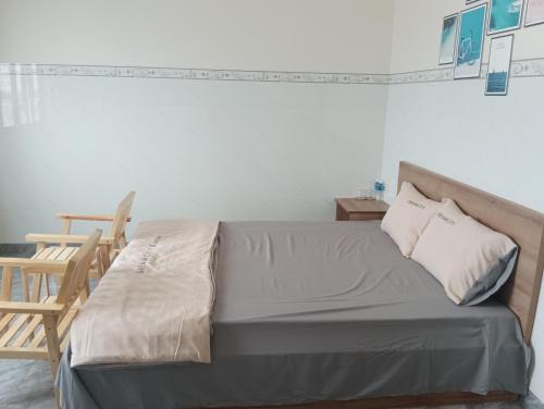 a bed in a room with a wooden chair at Homestay Dâu in Îlot du Sud