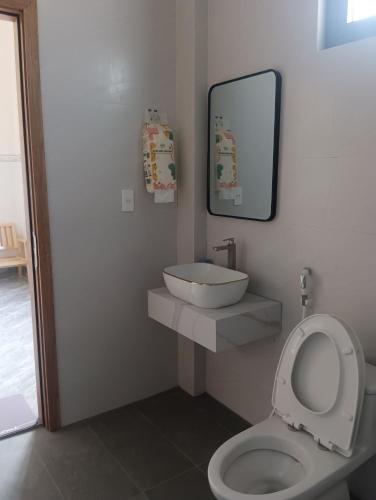 a bathroom with a toilet and a sink and a mirror at Homestay Dâu in Îlot du Sud