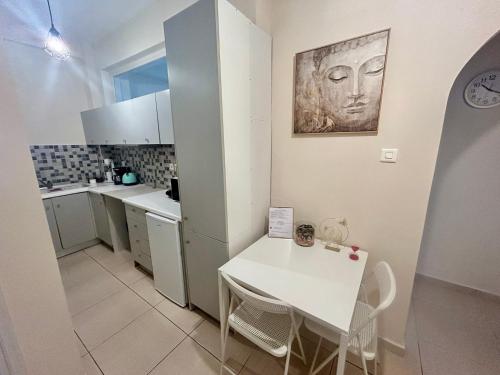 a kitchen with a white table and a white counter top at AKTIS apartment 4 near airport in Artemida