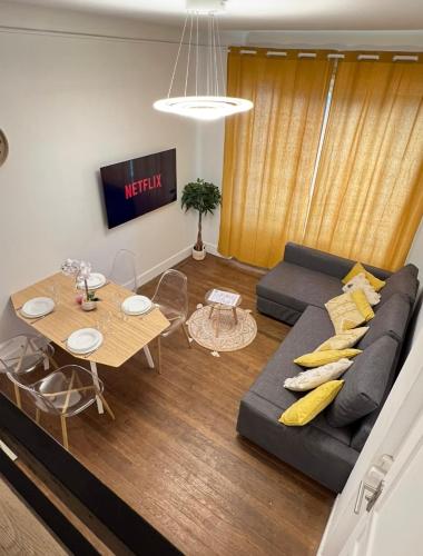 un salon avec un canapé et une table dans l'établissement PARIS-MONTROUGE Magnifique Studio Appartement de 35m2 - très cosy pour 1 à 6 personnes refait à neuf - ENTIRE APARTMENT LUXIRIOUS AND WARM - Montrouge Paris 14ème - Proche Aéroport Orly & Parc Expositions Porte de Versailles FREE WIFI GRATUIT, à Montrouge