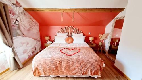 a bedroom with a bed with a heart on it at La Vallée Secrète - Love Hôtel 
