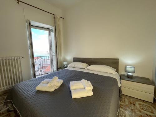 モンテ・サンタンジェロにあるCasa Larghetto - Affitti Brevi Italiaのベッドとタオル2枚のある寝室