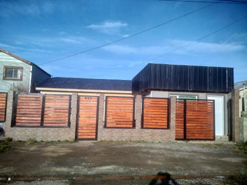 ein Backsteingebäude mit Holztüren und einem schwarzen Dach in der Unterkunft Alojamiento LUNNA in Río Grande