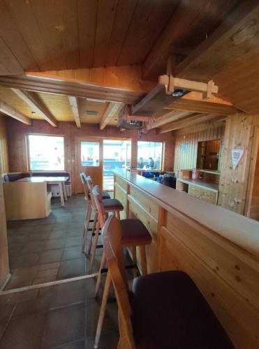 a bar in a restaurant with wooden walls and stools at Sauna, Pools mit XXL-Terasse oder Kinderkino in Sankt Englmar