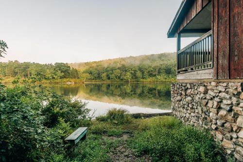 a bench sitting next to a lake next to a building at Mohican Outdoor Center in Blairstown