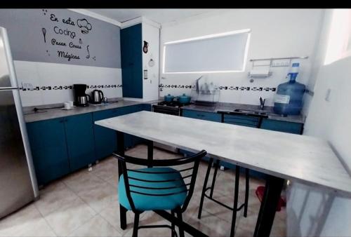 eine Küche mit blauen Schränken, einem Tisch und einem blauen Stuhl in der Unterkunft Alojamiento LUNNA in Río Grande